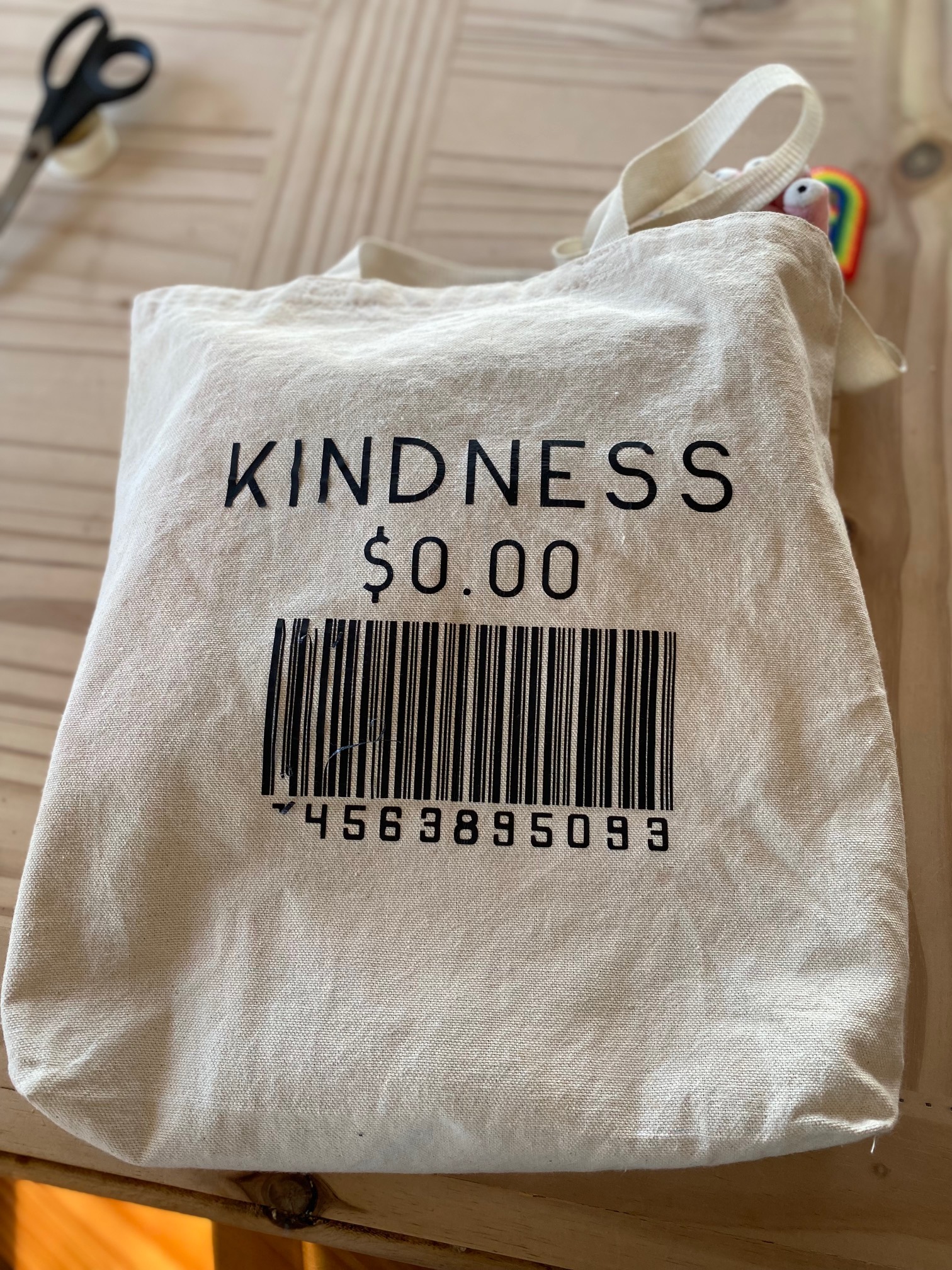 Tote bag with the word Kindness $0, above a barcode to demonstrate kindness as a core part to counselling