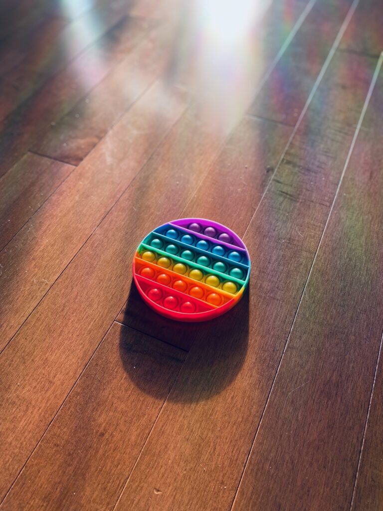 Rainbow fidget in sunlight to demonstrate accessible neurodiverse affirming counseling. 